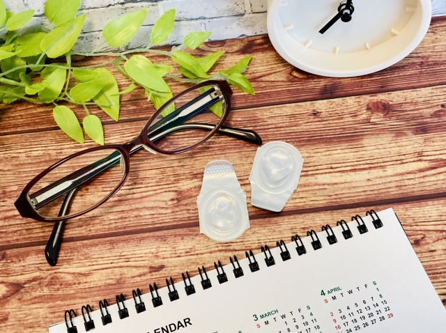 机に置いてあるメガネ、コンタクトレンズ